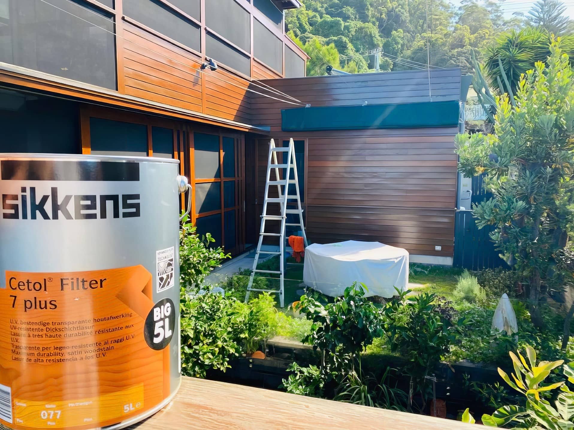 Painter working on an exterior house repaint in progress